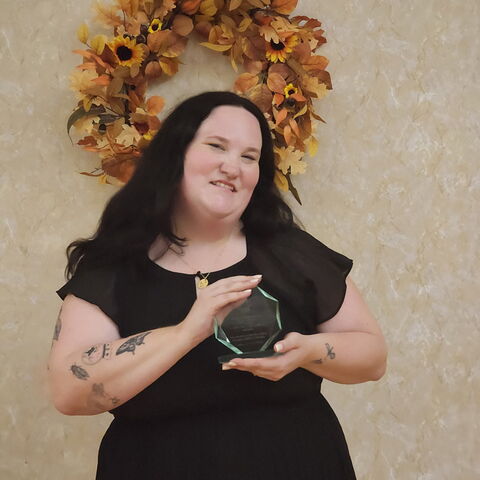 Lexi Rivett, president of the VAC, holding the UOVCC award of Innovation & Creative Excellence